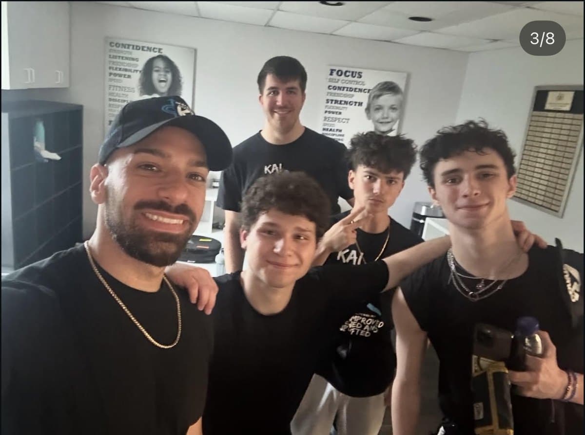 Charlie with crewmates in a studio, arms around each other